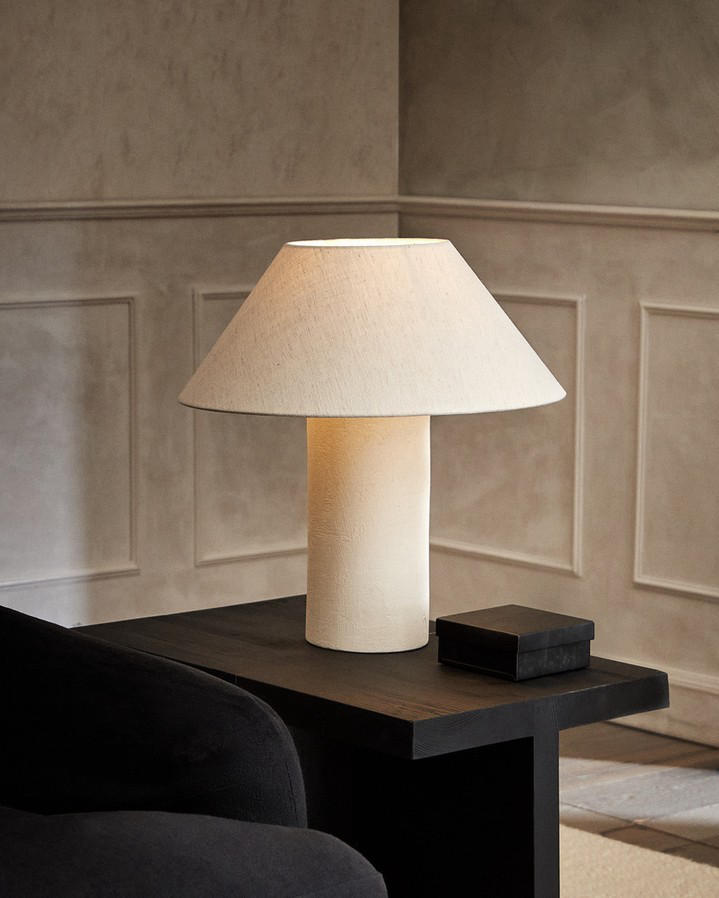 NEW IN · Lamp featuring a round ceramic base with a cement finish and a linen lampshade